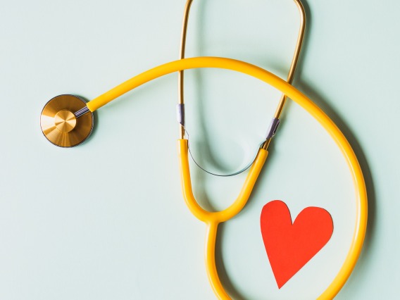 Stethoscope with a red paper heart next to it