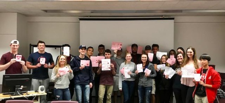 Picture of a group of students holding a pink paper